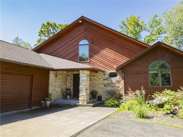 18845 64th Ave, Chippewa Falls, WI 54729 - view of front of home featuring stone siding, an attached garage, and driveway