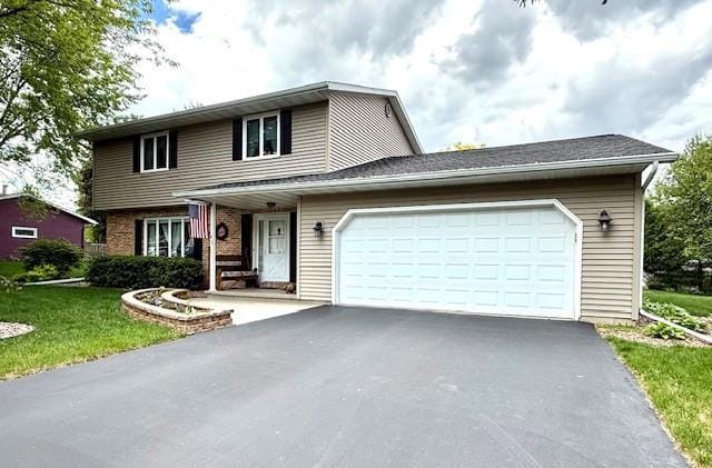 417 Raintree Dr, Fort Atkinson, WI 53538 - view of front of house with asphalt driveway, a garage, and a front yard