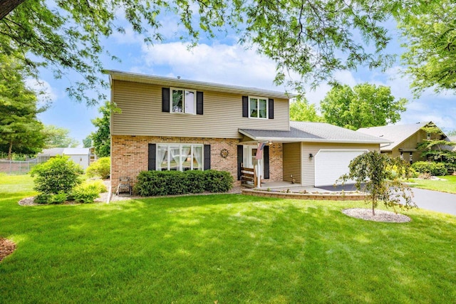 417 Raintree Dr, Fort Atkinson, WI 53538 - view of front of home with a garage, a front lawn, brick siding, and driveway