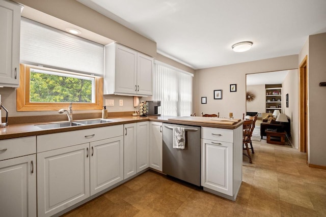417 Raintree Dr, Fort Atkinson, WI 53538 - kitchen with stainless steel dishwasher, a peninsula, white cabinets, and light floors