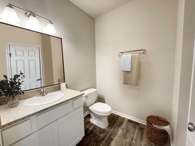 620 E Maple Beach Dr, Edgerton, WI 53534 - bathroom featuring wood finished floors, toilet, vanity, and baseboards