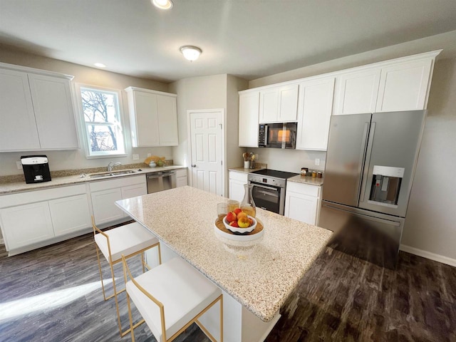 620 E Maple Beach Dr, Edgerton, WI 53534 - kitchen with appliances with stainless steel finishes, a sink, white cabinets, dark wood-style flooring, and recessed lighting