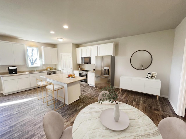 620 E Maple Beach Dr, Edgerton, WI 53534 - kitchen featuring appliances with stainless steel finishes, a sink, a kitchen island, white cabinetry, and baseboards
