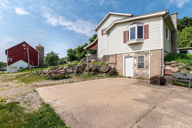 4884 Brewery Rd, Cross Plains, WI 53528 - view of side of property with a barn, stairs, an outdoor structure, and a chimney