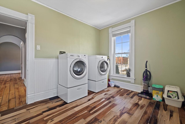 1105 N 6th St, Sheboygan, WI 53081 - laundry area featuring separate washer and dryer, crown molding, wood-type flooring, arched walkways, and baseboards