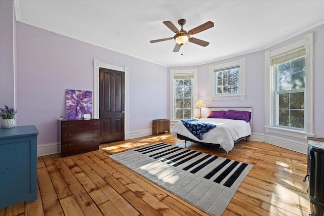 1105 N 6th St, Sheboygan, WI 53081 - bedroom featuring crown molding, radiator, multiple windows, hardwood / wood-style floors, and baseboards