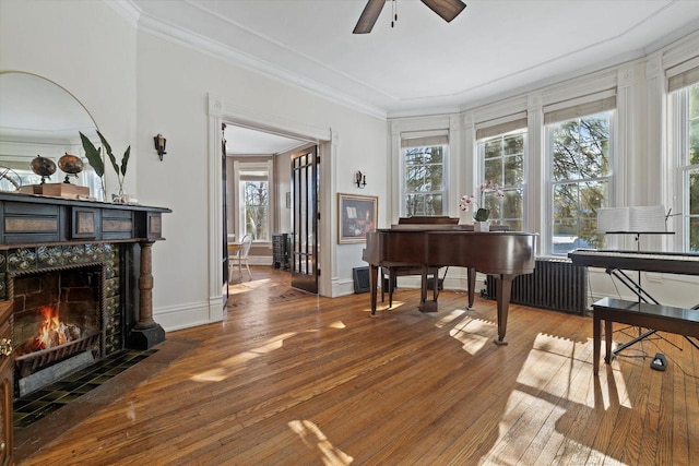 1105 N 6th St, Sheboygan, WI 53081 - living area featuring radiator heating unit, hardwood / wood-style flooring, a ceiling fan, healthy amount of natural light, and crown molding