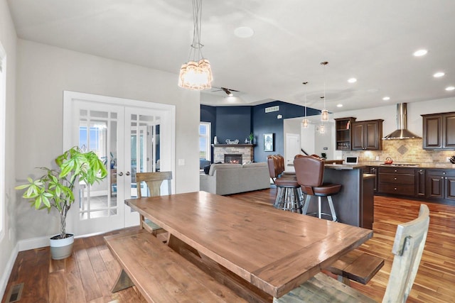 3403 Whistling Wind Way, Sun Prairie, WI 53590 - dining room featuring french doors, wood finished floors, recessed lighting, a fireplace, and a chandelier