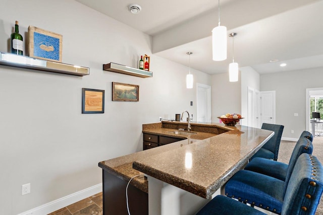 3403 Whistling Wind Way, Sun Prairie, WI 53590 - kitchen with a breakfast bar area, dark stone countertops, hanging light fixtures, a peninsula, and recessed lighting
