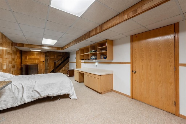 404 Walnut St, Spooner, WI 54801 - bedroom with a drop ceiling, light colored carpet, baseboards, and wood walls