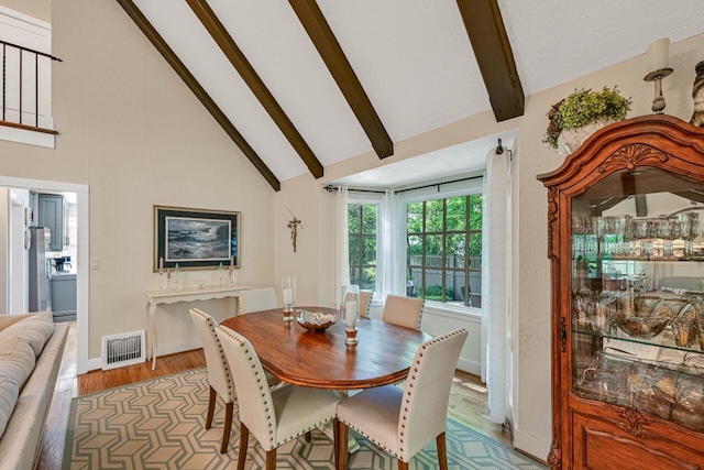 933 Juneau Dr, Fontana, WI 53125 - dining area featuring wood finished floors, beamed ceiling, high vaulted ceiling, and baseboards