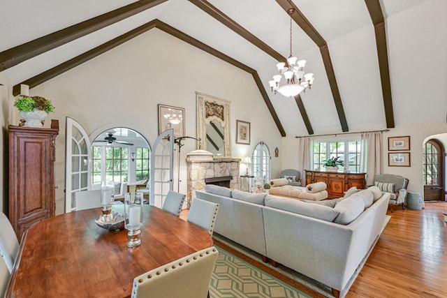 933 Juneau Dr, Fontana, WI 53125 - living room with high vaulted ceiling, beamed ceiling, a chandelier, light wood finished floors, and a ceiling fan
