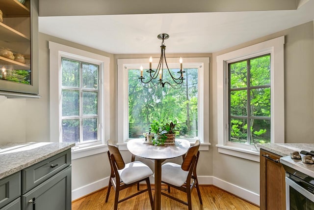 933 Juneau Dr, Fontana, WI 53125 - dining space with a chandelier, baseboards, light wood-style floors, and healthy amount of natural light