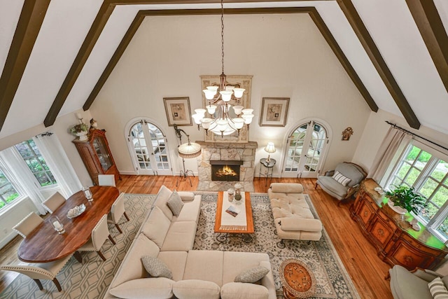 933 Juneau Dr, Fontana, WI 53125 - living room with high vaulted ceiling, wood finished floors, beamed ceiling, a chandelier, and a lit fireplace