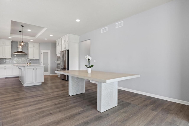 1279 E Hickory Creek Ct, Oak Creek, WI 53154 - kitchen with stainless steel refrigerator, a kitchen island with sink, recessed lighting, light countertops, and a breakfast bar