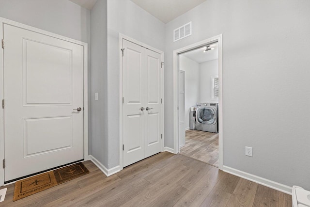 1279 E Hickory Creek Ct, Oak Creek, WI 53154 - foyer with washer / dryer, light wood-style flooring, and baseboards