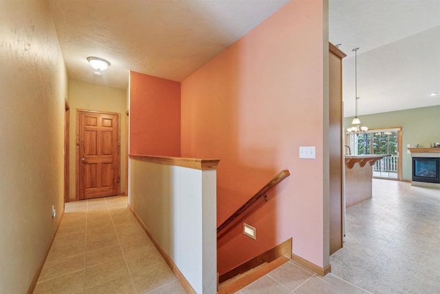 536 Coonen Dr, Combined Locks, WI 54113 - hallway featuring an upstairs landing, a chandelier, baseboards, and light tile patterned floors