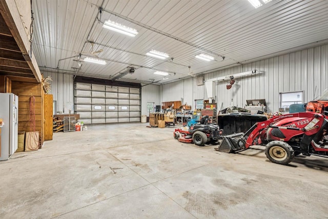 N6471 12 Corners Rd, Black Creek, WI 54106 - garage featuring freestanding refrigerator, metal wall, and a workshop area
