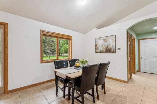 N6471 12 Corners Rd, Black Creek, WI 54106 - dining space with baseboards, light tile patterned floors, arched walkways, and lofted ceiling