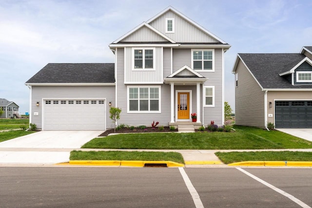447 Crusader Pt, Waunakee, WI 53597 - view of front of house with board and batten siding, a front yard, driveway, and a garage