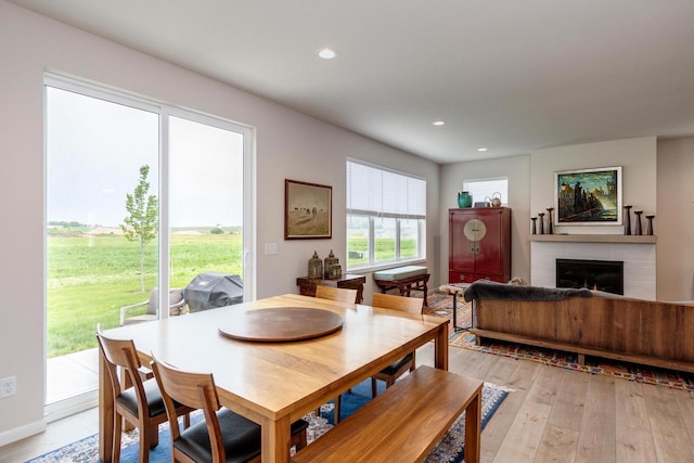 447 Crusader Pt, Waunakee, WI 53597 - dining area with light wood-type flooring, a lit fireplace, and recessed lighting