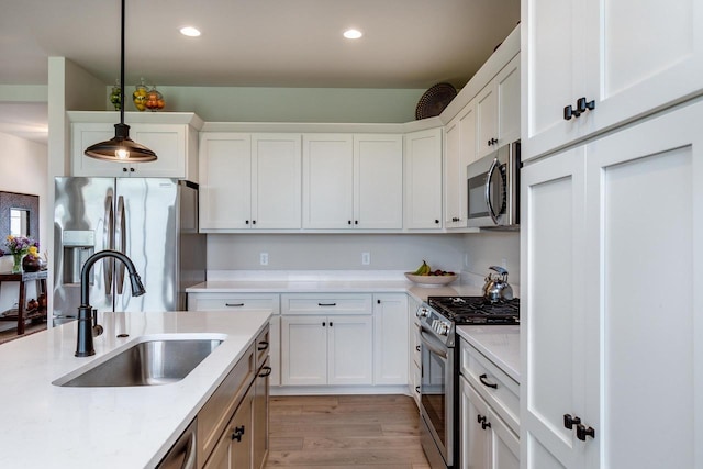 447 Crusader Pt, Waunakee, WI 53597 - kitchen with appliances with stainless steel finishes, a sink, white cabinetry, pendant lighting, and recessed lighting