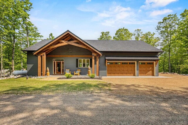 7272 Freedom Trl, Wabeno, WI 54566 - view of front of home featuring a garage, driveway, a front lawn, and a shingled roof