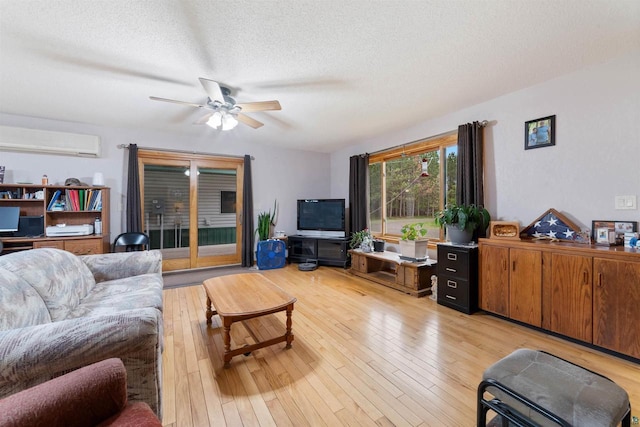 14303 Rock N Roll Ln, Gordon, WI 54838 - living room with an AC wall unit, a textured ceiling, a ceiling fan, and light wood-style floors