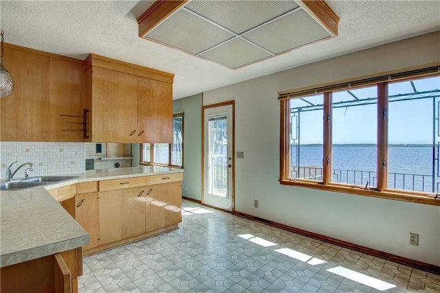 8303 163rd St, Chippewa Falls, WI 54729 - kitchen with light countertops, a water view, tasteful backsplash, light brown cabinets, and a peninsula