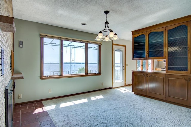 8303 163rd St, Chippewa Falls, WI 54729 - unfurnished dining area featuring a chandelier, plenty of natural light, a textured ceiling, and a fireplace