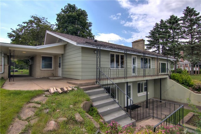 8303 163rd St, Chippewa Falls, WI 54729 - view of front of house featuring a chimney, stairway, an attached carport, and brick siding