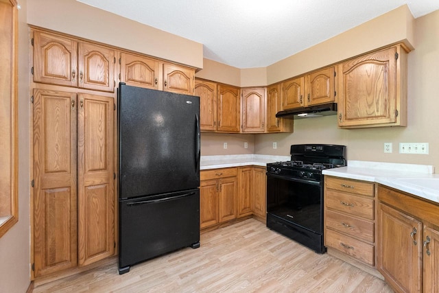 N3661 Peters Rd, La Crosse, WI 54601 - kitchen featuring black appliances, under cabinet range hood, brown cabinets, and light countertops