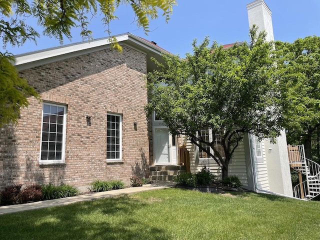 1537 Highland Dr Unit 8-52, Lake Geneva, WI 53147 - view of front of home with brick siding, a front yard, and a chimney