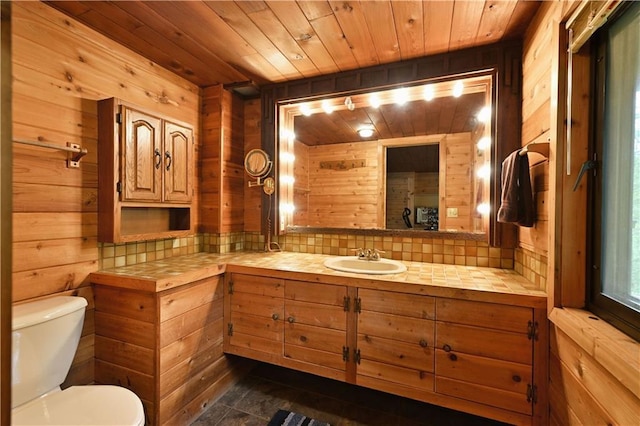 N5575 Schultz Ln, Stone Lake, WI 54876 - half bathroom with toilet, wood ceiling, wood walls, vanity, and decorative backsplash