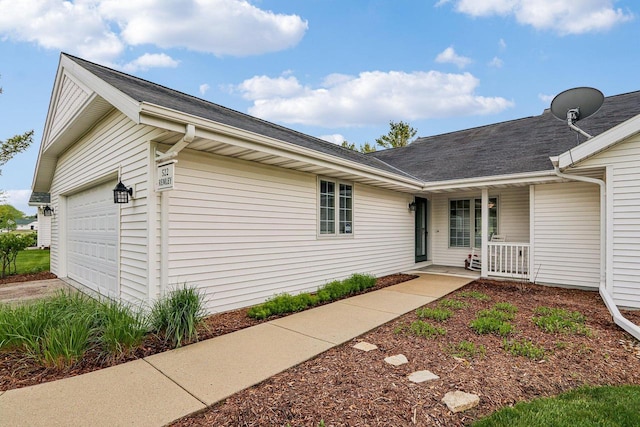 522 Otto Way, Elkhart Lake, WI 53020 - view of side of home featuring a porch, an attached garage, driveway, and a shingled roof
