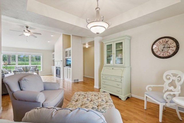 522 Otto Way, Elkhart Lake, WI 53020 - living room with lofted ceiling, baseboards, light wood-type flooring, ceiling fan, and a fireplace