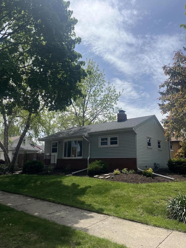 2507 S 94th St, West Allis, WI 53227 - view of front facade featuring a chimney and a front yard