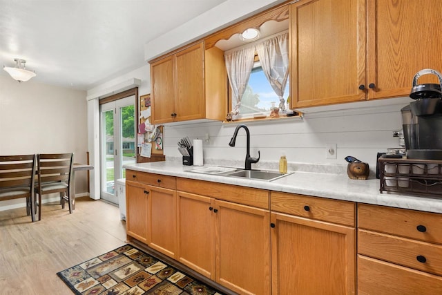 1413 E Marquette St, Appleton, WI 54911 - kitchen featuring a sink, light countertops, light wood-style flooring, and brown cabinetry
