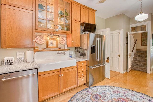 150 Rountree Ave, Platteville, WI 53818 - kitchen with appliances with stainless steel finishes, light wood finished floors, a sink, and glass insert cabinets