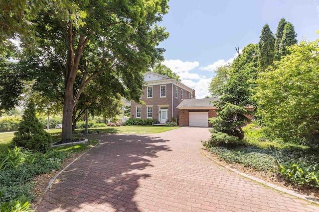 150 Rountree Ave, Platteville, WI 53818 - view of front of house with decorative driveway, brick siding, a garage, and a front yard