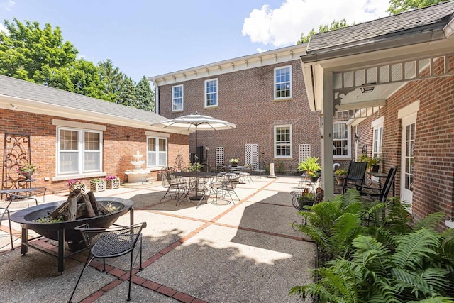 150 Rountree Ave, Platteville, WI 53818 - rear view of house featuring a patio area, a fire pit, and brick siding