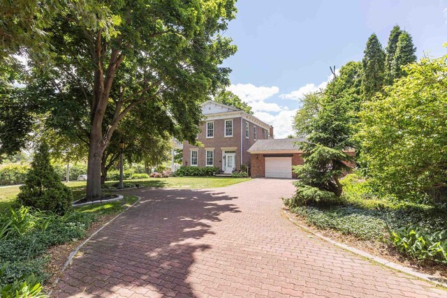 150 Rountree Ave, Platteville, WI 53818 - view of front of house with decorative driveway, brick siding, a garage, and a front yard