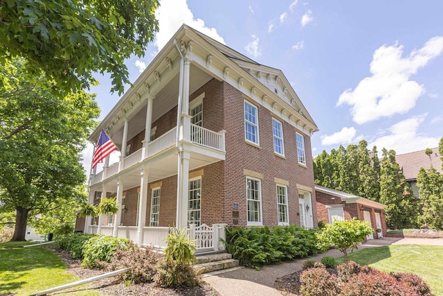 150 Rountree Ave, Platteville, WI 53818 - view of front of home featuring brick siding, a balcony, covered porch, and a front lawn