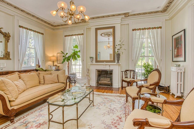 150 Rountree Ave, Platteville, WI 53818 - living area with ornamental molding, plenty of natural light, a chandelier, light wood finished floors, and radiator heating unit