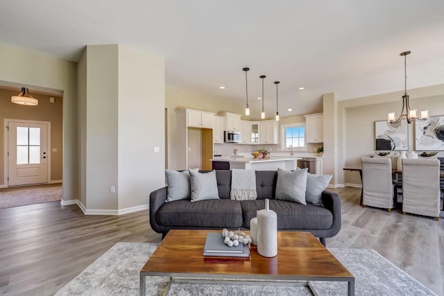 1320 Prairie Creek Cir Unit 2, Oconomowoc, WI 53066 - living room with light wood-style floors, a chandelier, and recessed lighting