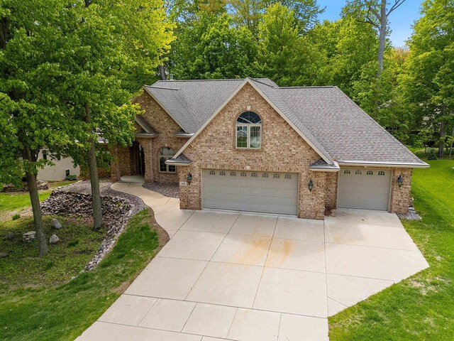 448 Harvest Rd, Green Bay, WI 54302 - view of front of property featuring a garage, brick siding, a front lawn, a shingled roof, and concrete driveway