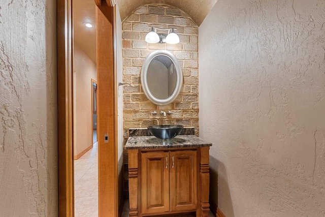 448 Harvest Rd, Green Bay, WI 54302 - half bathroom with vanity, tile patterned flooring, a textured wall, and lofted ceiling