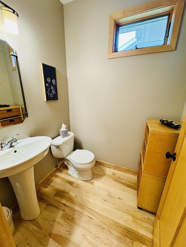 2659 Dungarvan Rd, Fitchburg, WI 53711 - half bathroom featuring wood finished floors, toilet, baseboards, and a sink