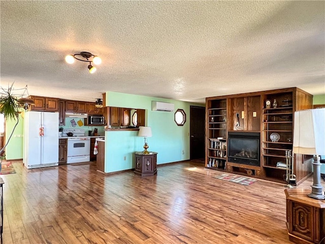 999 Mcgill Point Rd, Weyerhaeuser, WI 54895 - living room featuring a textured ceiling, a wall mounted air conditioner, wood finished floors, and baseboards