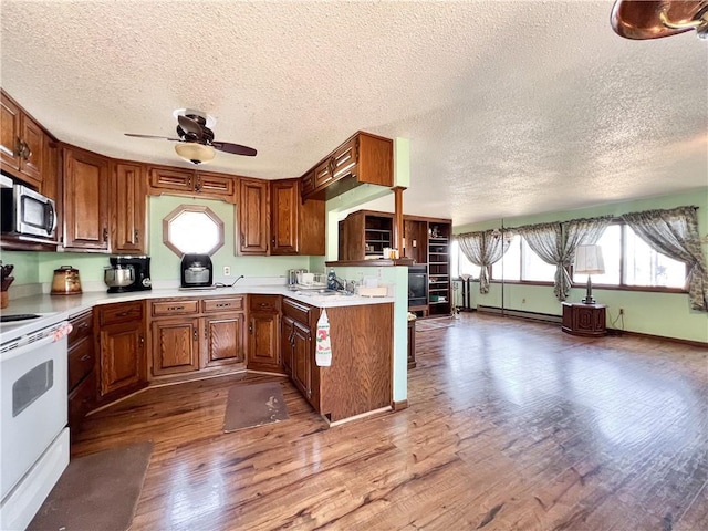 999 Mcgill Point Rd, Weyerhaeuser, WI 54895 - kitchen featuring white electric stove, stainless steel microwave, a sink, wood finished floors, and a textured ceiling